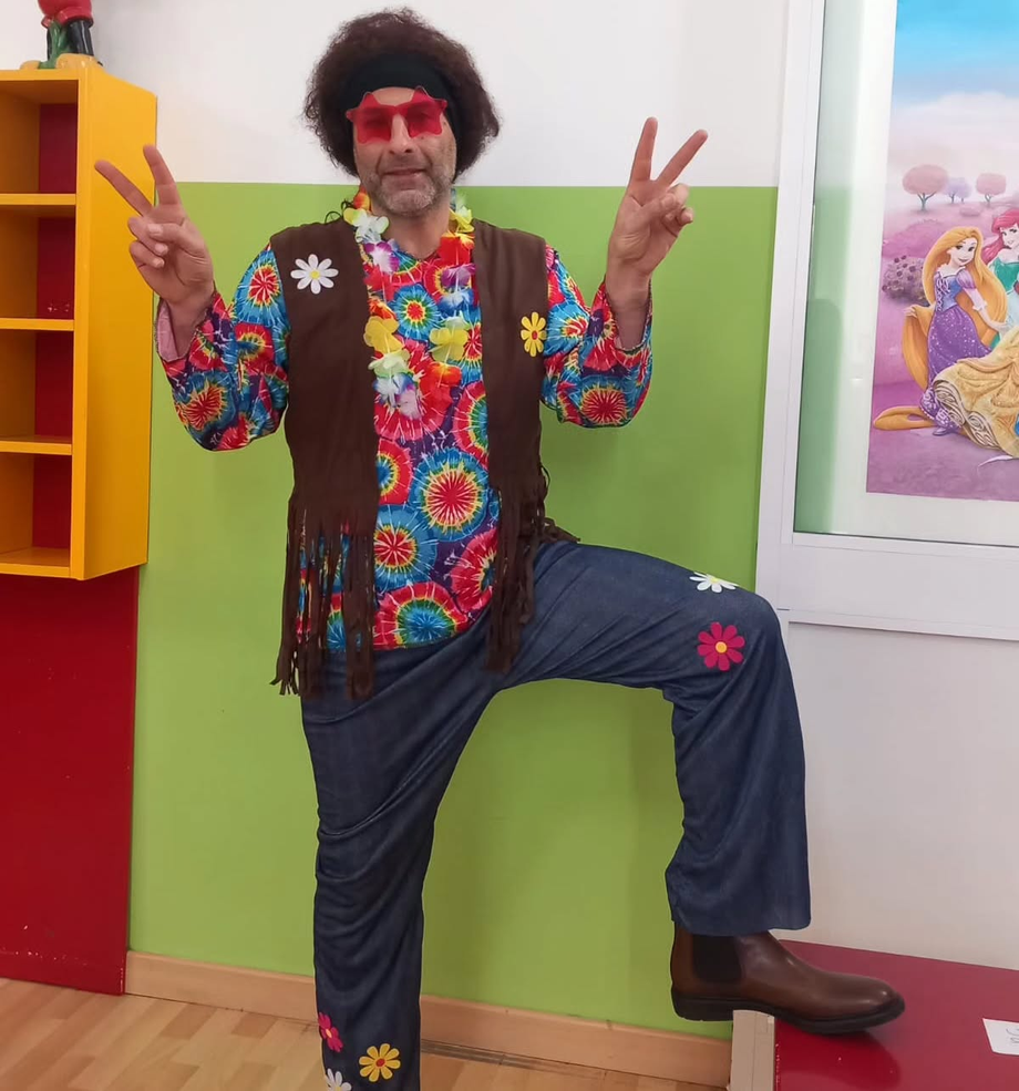 Un uomo in costume hippie fa il segno della pace