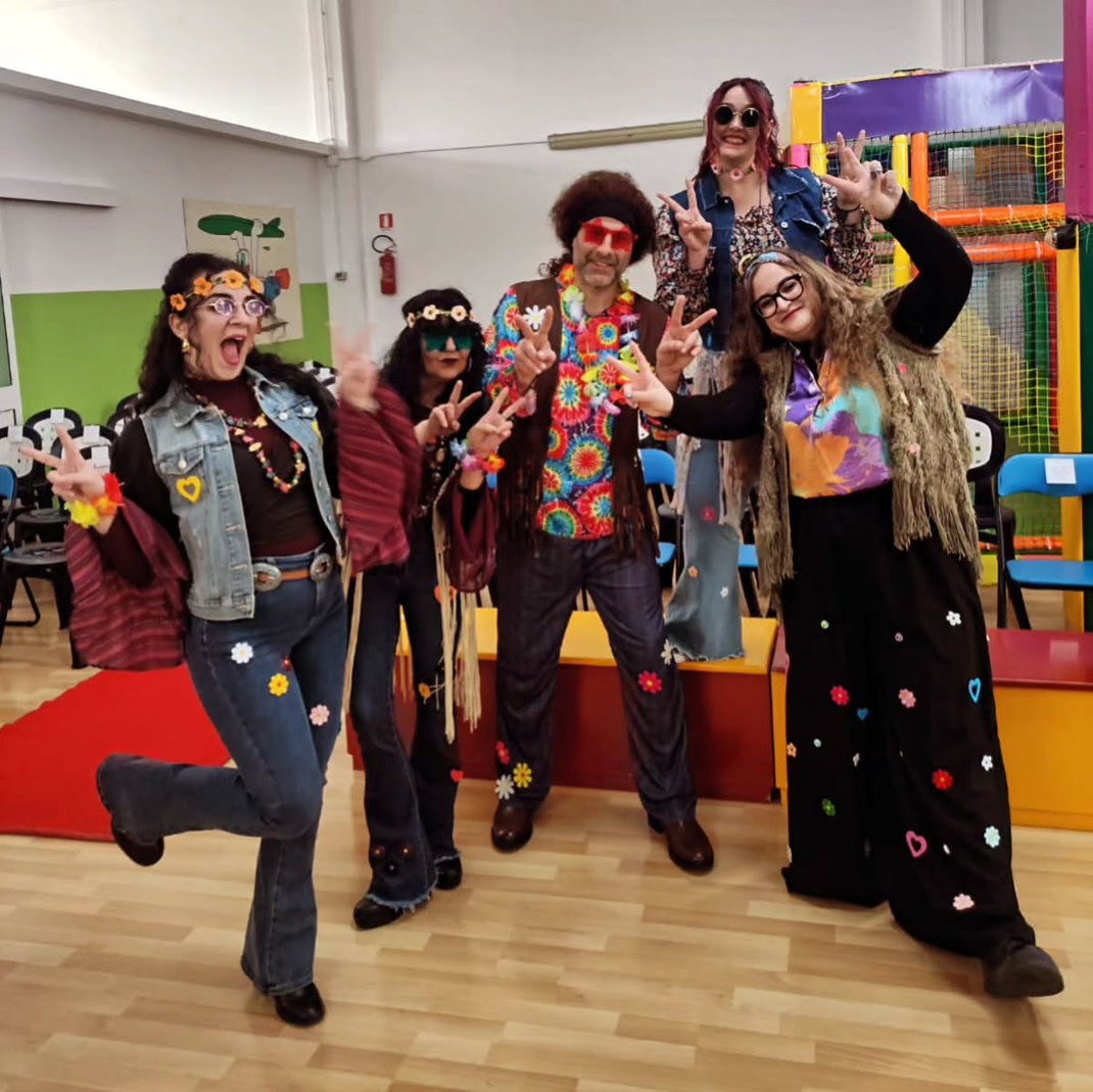 Un gruppo di persone vestite con costumi hippie posano per una foto