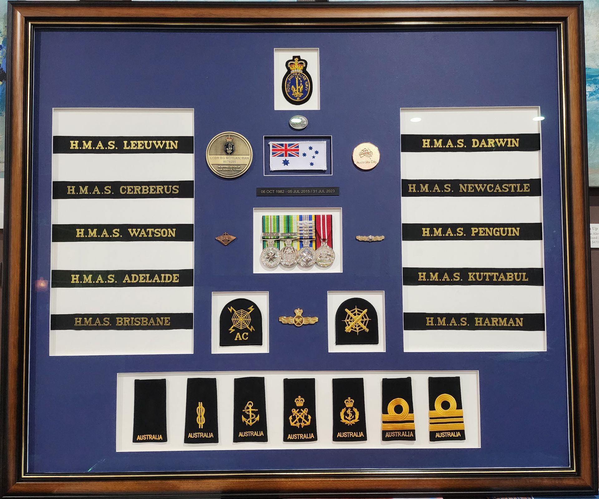 A framed display of medals and badges including one for a captain