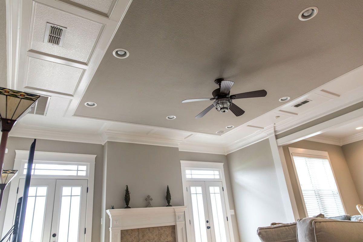 A living room with a ceiling fan and a fireplace