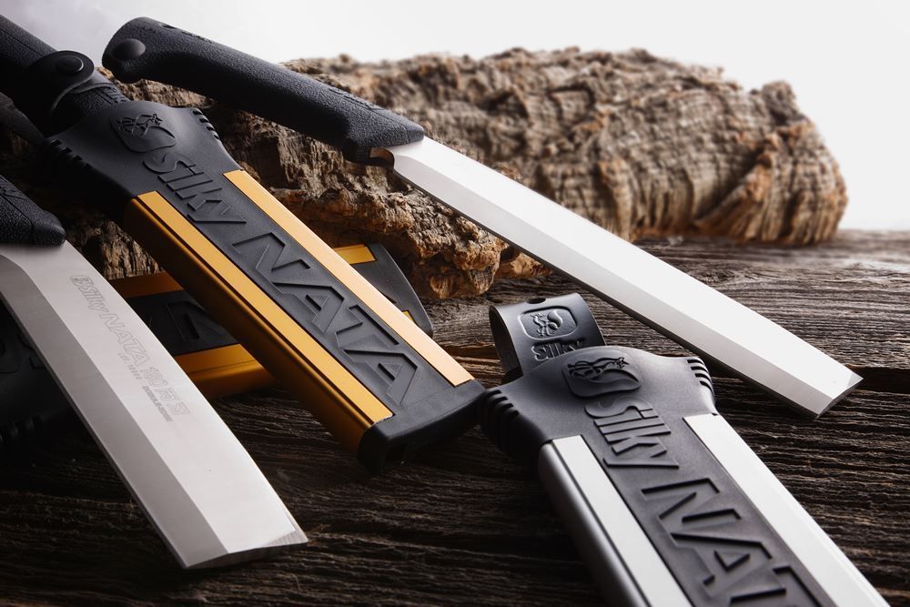 A Few Knives Are Laying On A Wooden Table And One Of Them Has The Word Sky On It — Tree Arrangements in Stratford, QLD