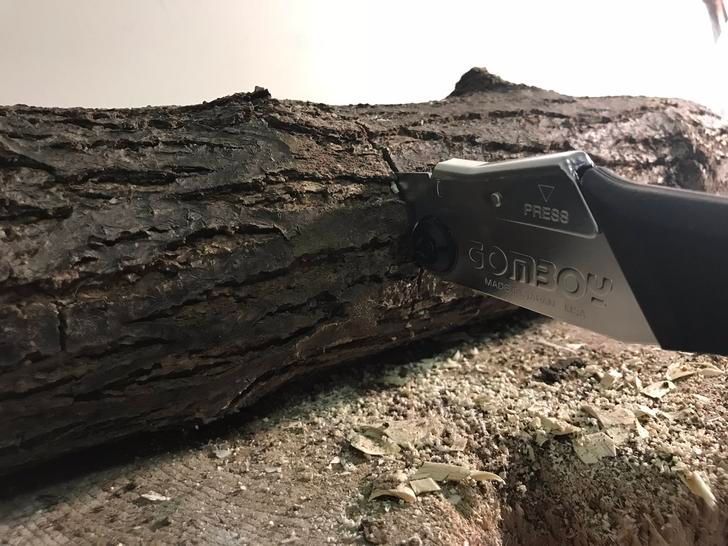 A Person Is Cutting A Piece Of Wood With A Saw — Tree Arrangements in Stratford, QLD 