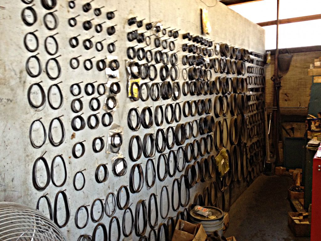 Wall displaying numerous circular gaskets in a workshop setting.