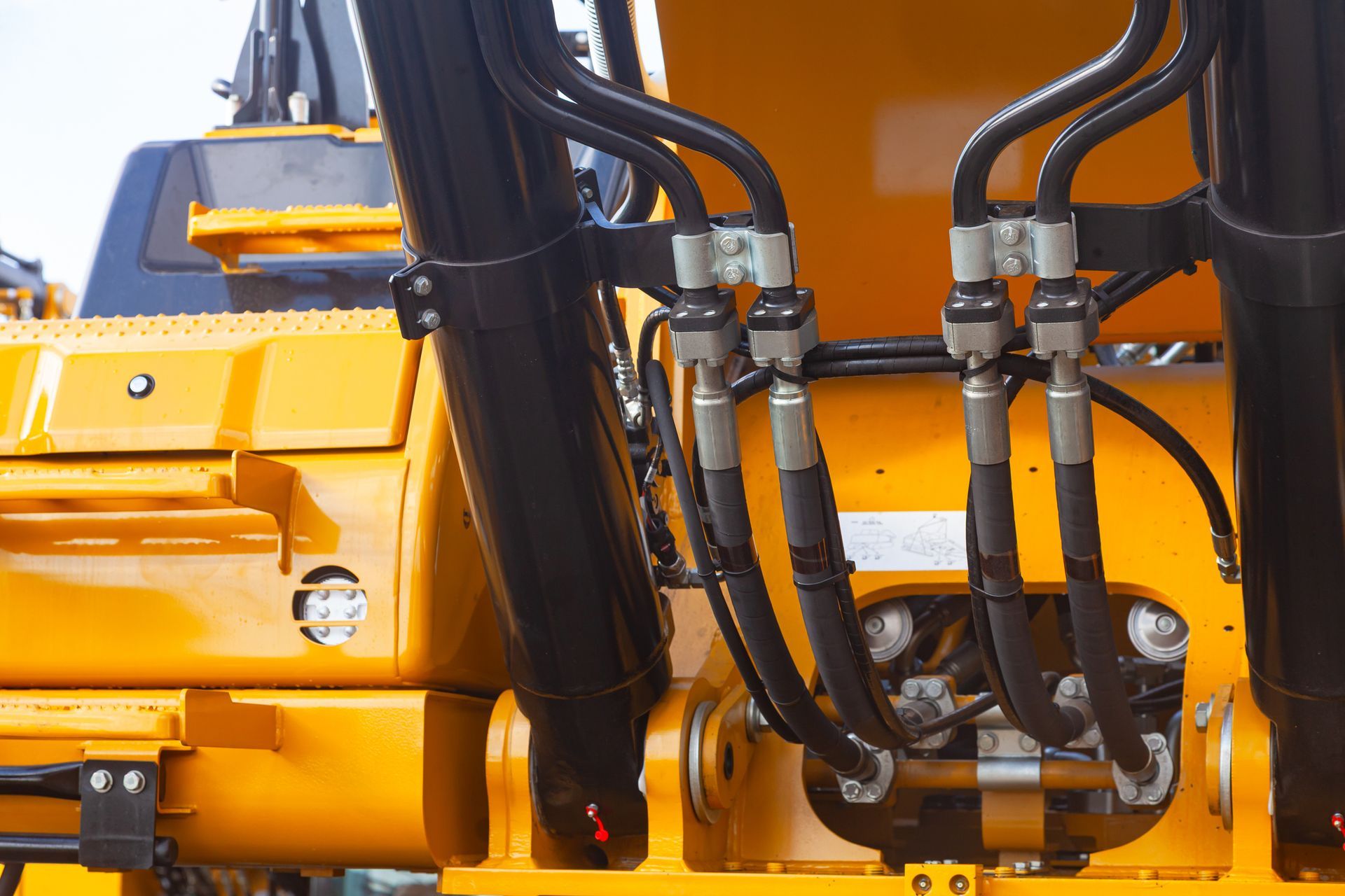 Close-up of hydraulic hoses and connectors attached to heavy construction equipment. Close-up of hydraulic hoses and connectors attached to heavy construction equipment.