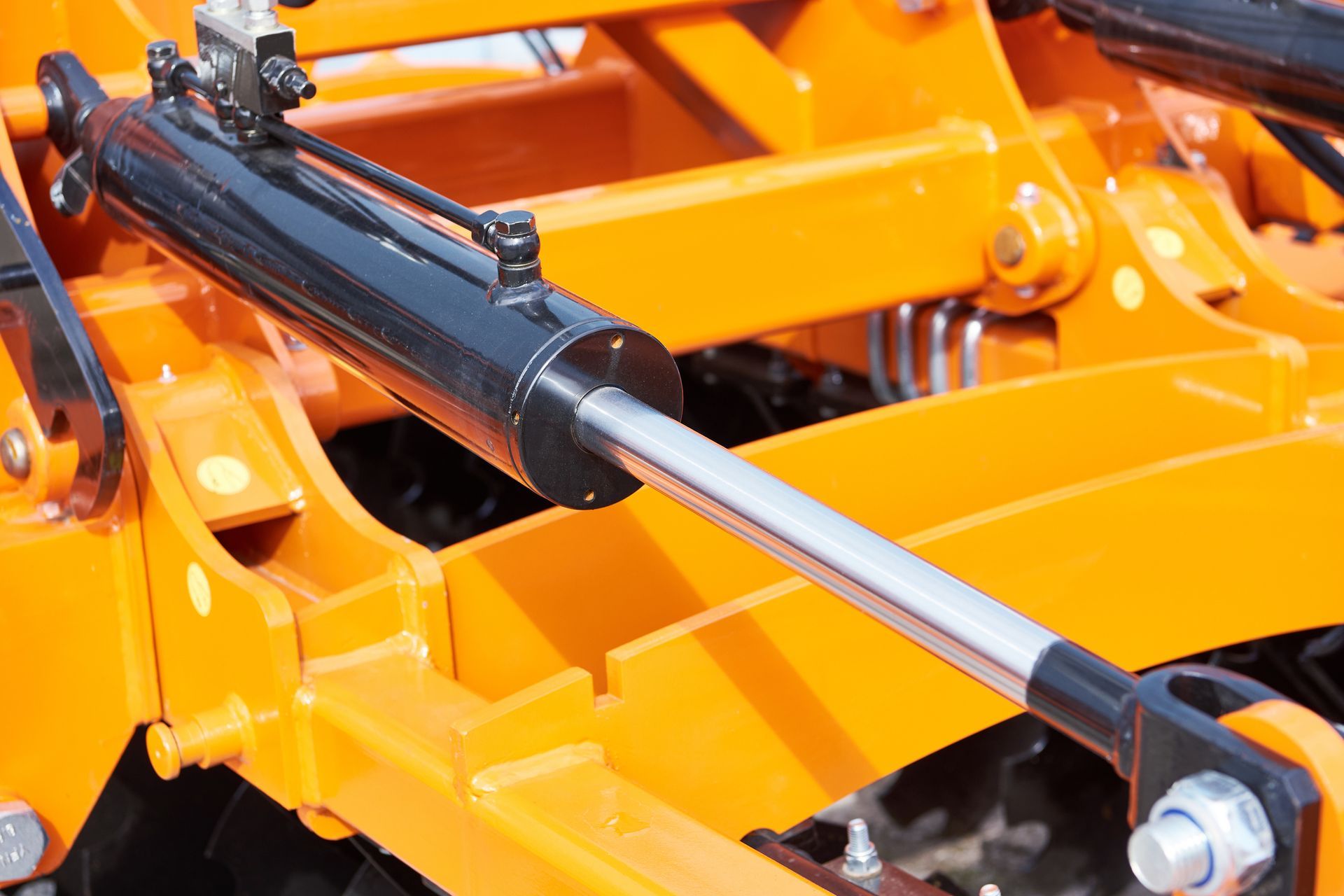 Close-up of hydraulic cylinder on industrial machine, highlighting hydraulic repair service.