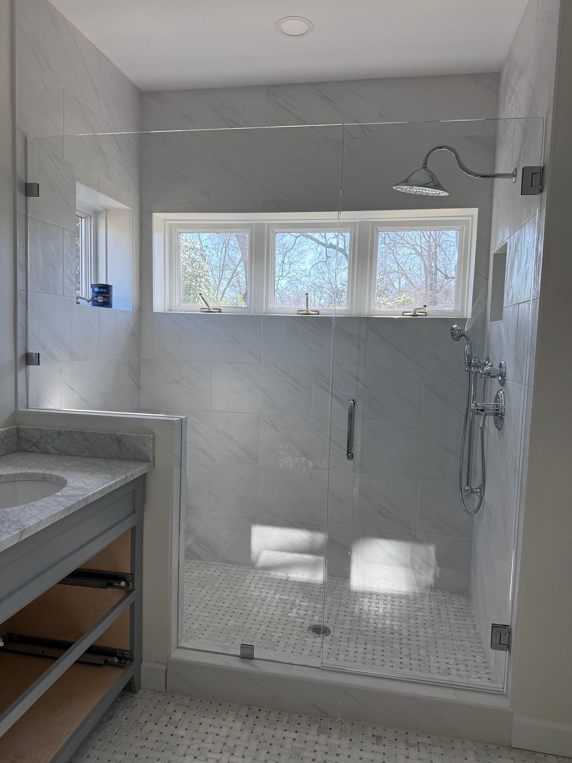 A bathroom with a walk in shower and a sink