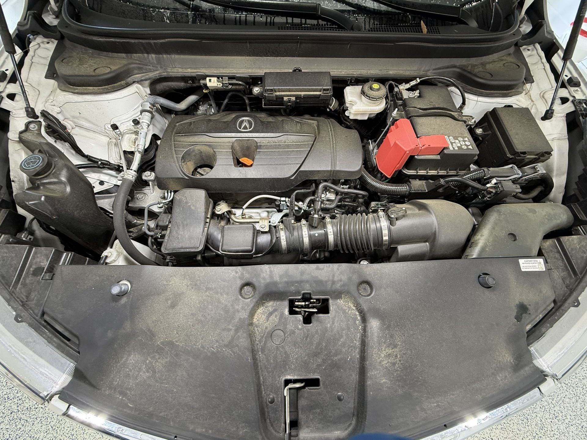 Black car back seat with floor mats, showing texture and some debris.