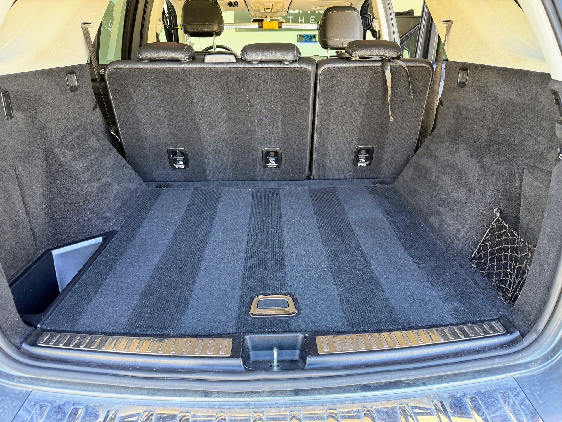 Interior of a black truck; seats, console, dashboard, and floor mat.
