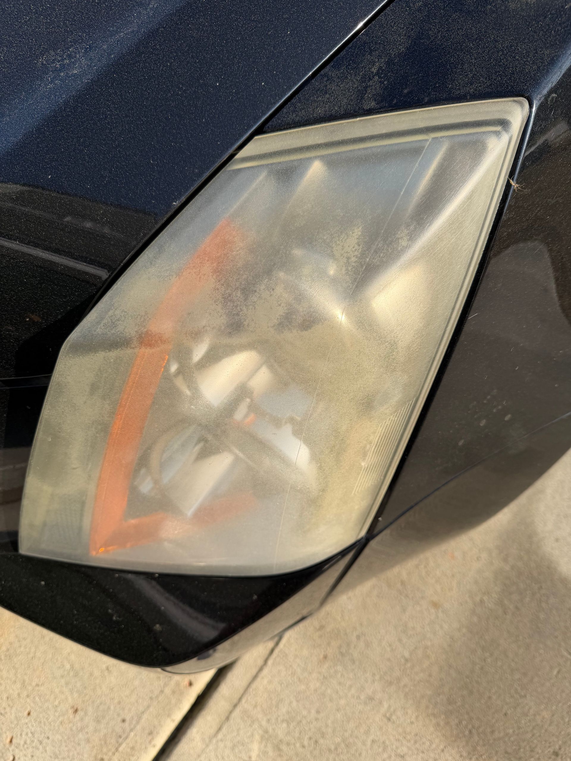 Burgundy Honda Ridgeline pickup truck parked on a driveway in front of a house.