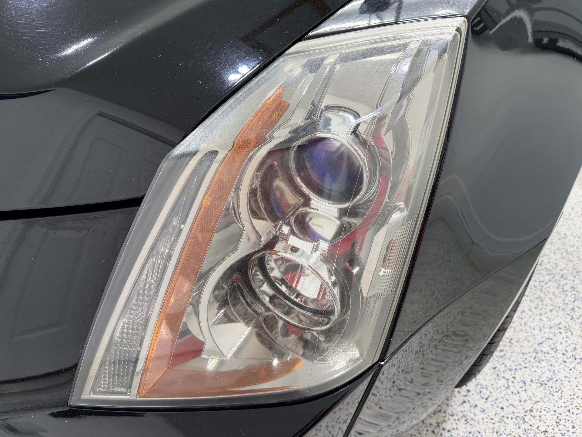 Maroon Honda Ridgeline pickup truck parked on a paved road next to a curb with green grass in front of houses.