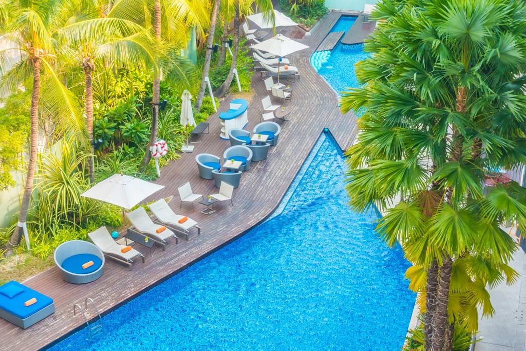 Top down view of a hotel with pool chairs next to the pool