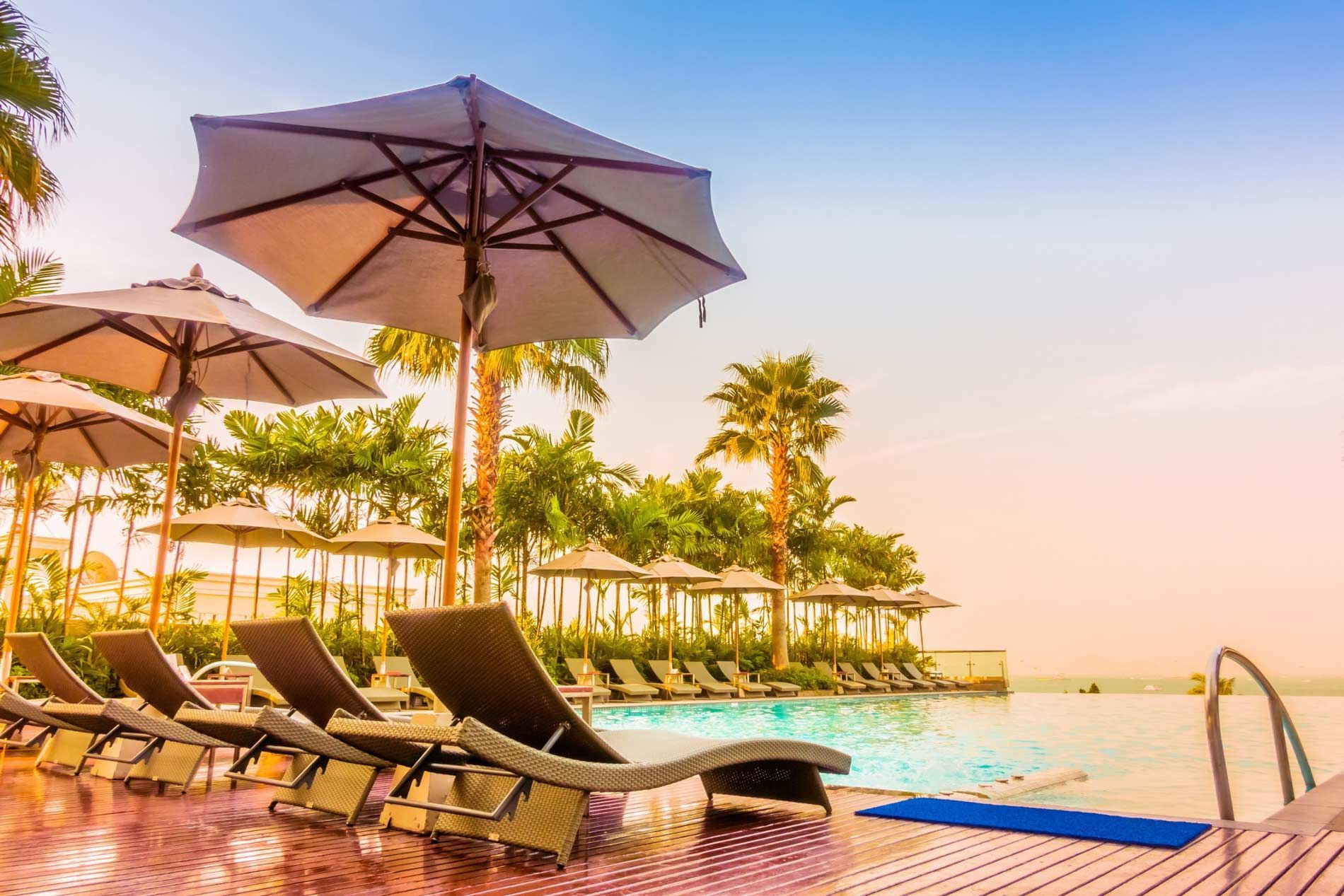 Pool during a sunset showing sun loungers