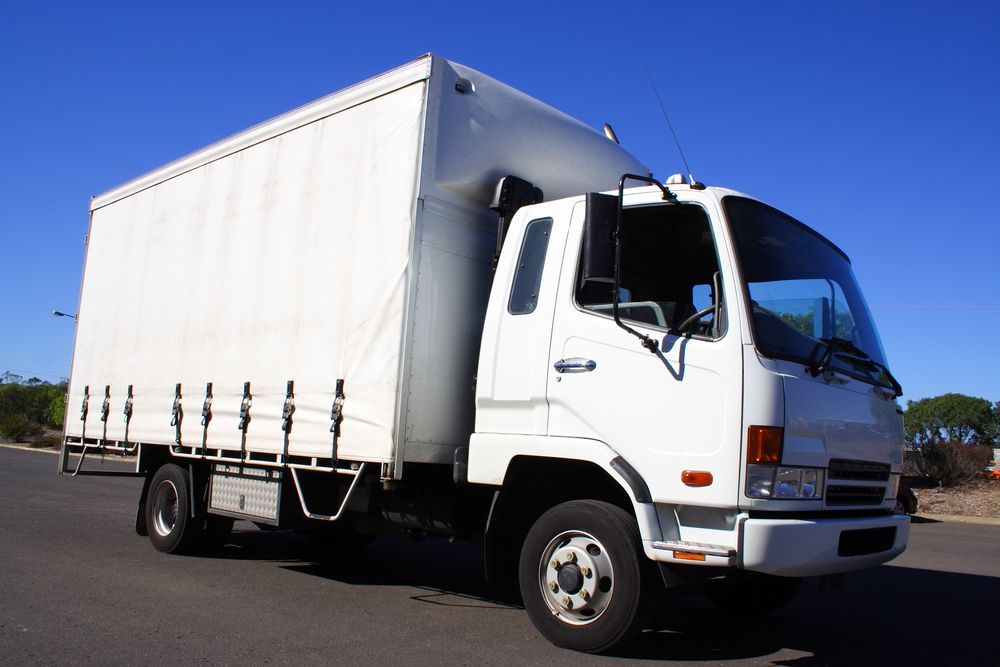White Box Truck on a Paved Road Against a Clear Blue Sky — Hines Logistic Pty Ltd In Port Macquarie, NSW