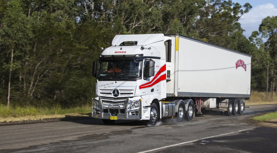 White Semi-truck With Red Accents Driving on a Paved Road — Hines Logistic Pty Ltd In Port Macquarie, NSW