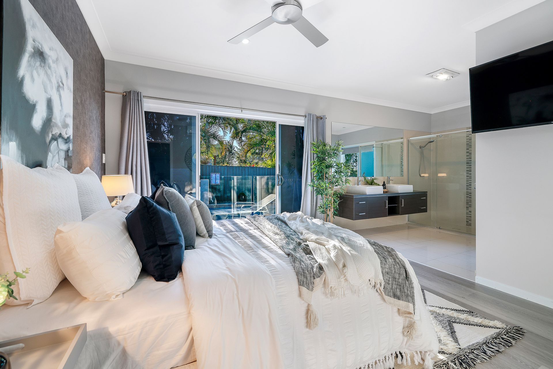 A bedroom with a large bed and a ceiling fan.