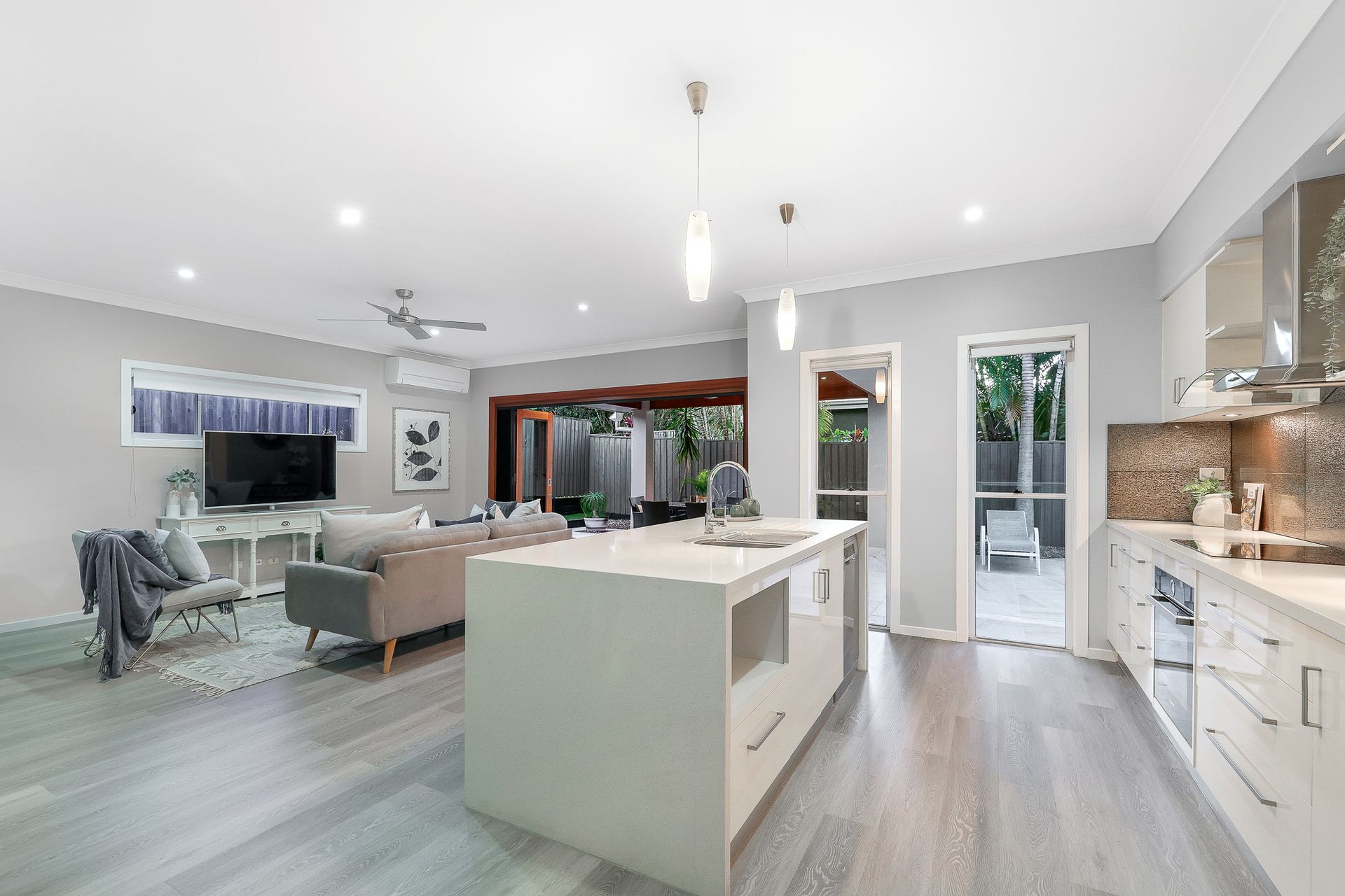 A kitchen and living room in a house with a large island in the middle.