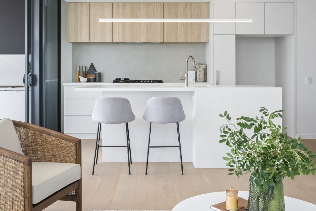 A living room with a chair , table , and kitchen.