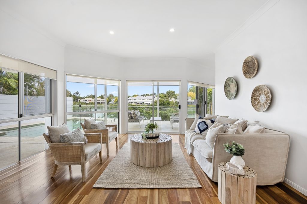 A living room with a couch , chairs , tables and a view of a pool.