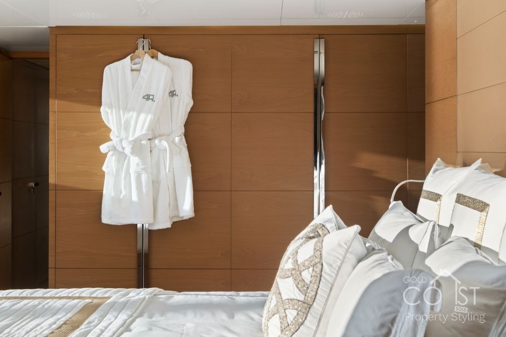 A bedroom with a bed and a robe hanging on the wall.