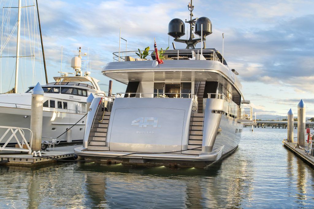 A large yacht is docked at a marina.