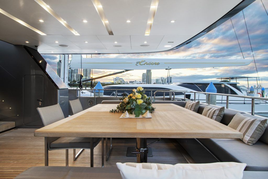 There is a long wooden table with a vase of flowers on it.