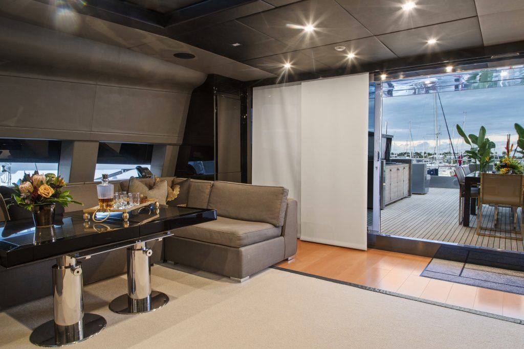 A living room with a couch , table , chairs and a large window.