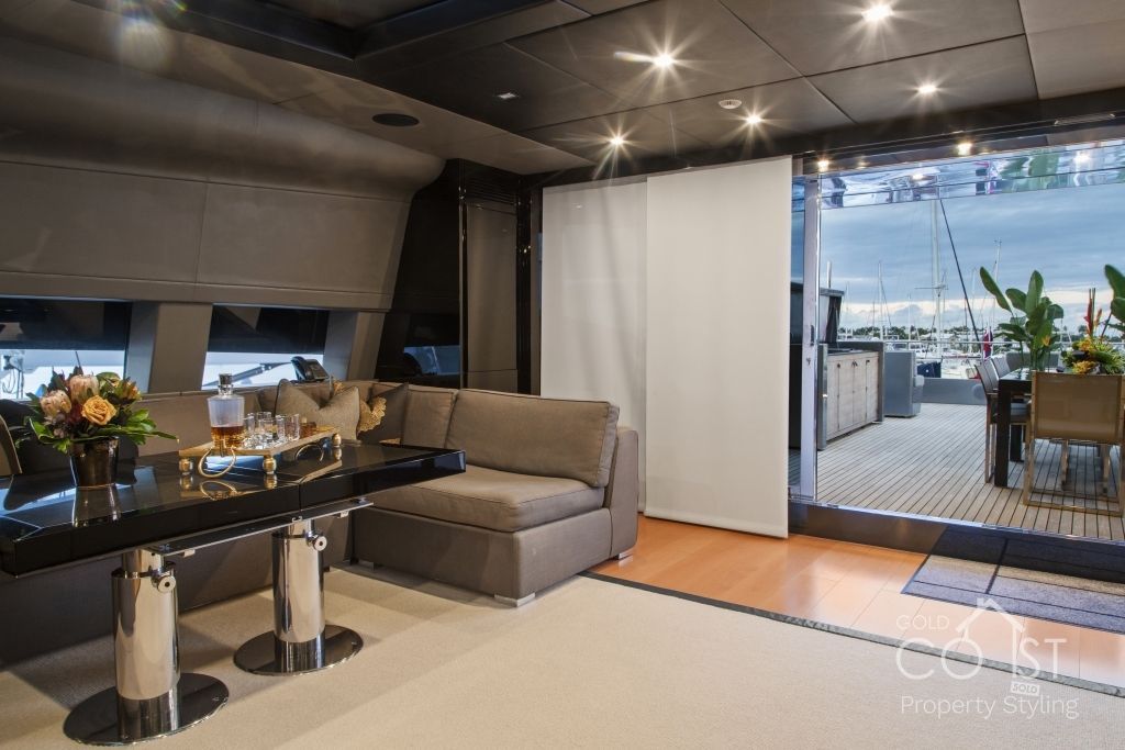 A living room with a couch , table , chairs and a large window.