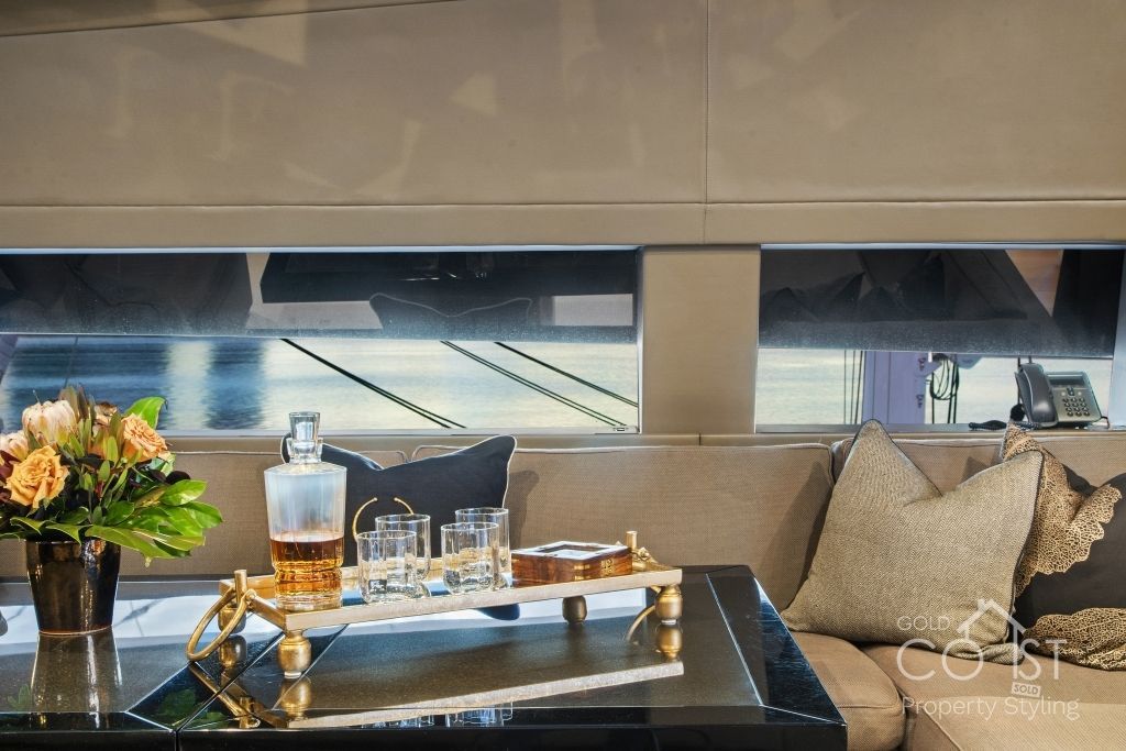 A living room with a couch and a table with a decanter and glasses on it