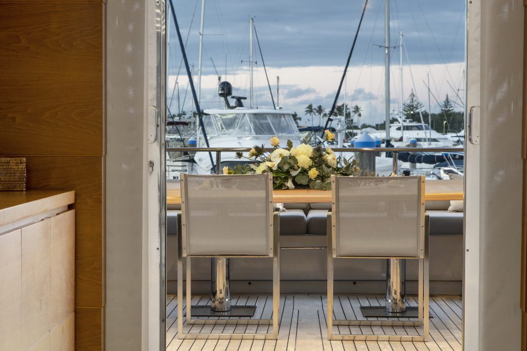 There is a table and chairs on the deck of a boat.