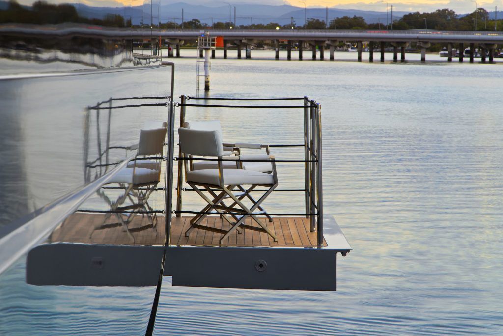 Two chairs are sitting on a dock in the water
