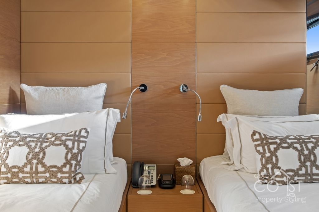 A bedroom with two beds and a nightstand with a phone on it.