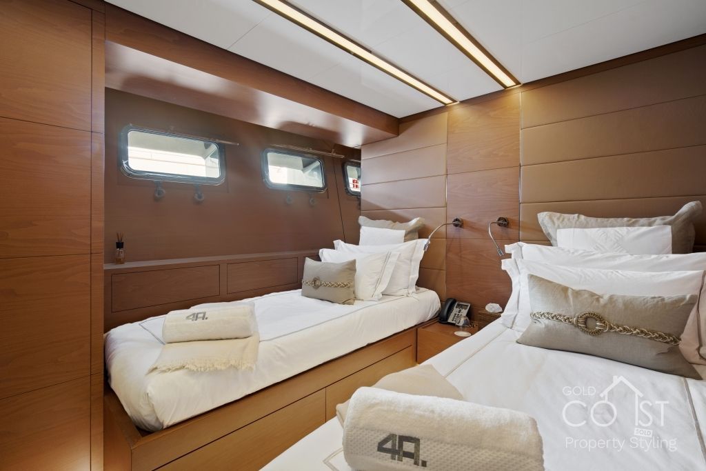 A bedroom on a boat with two beds and a window