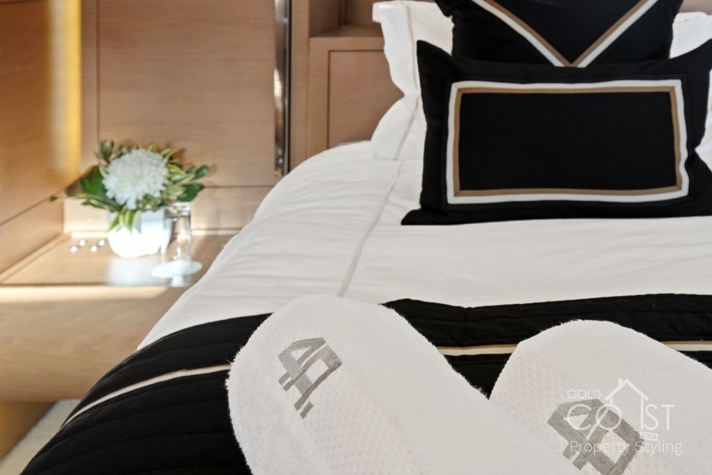 A bed with a black and white comforter and a pair of slippers with the number 40 on them