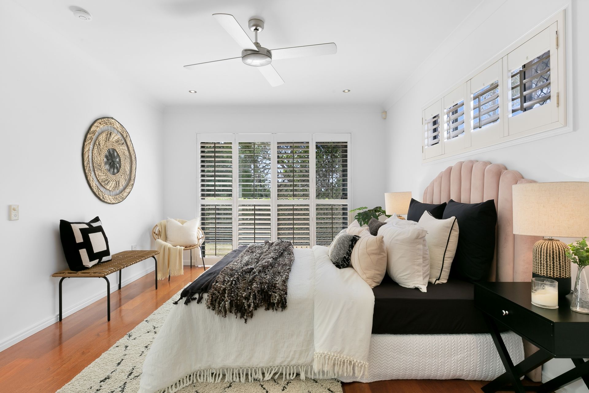 A bedroom with a large bed and a ceiling fan.