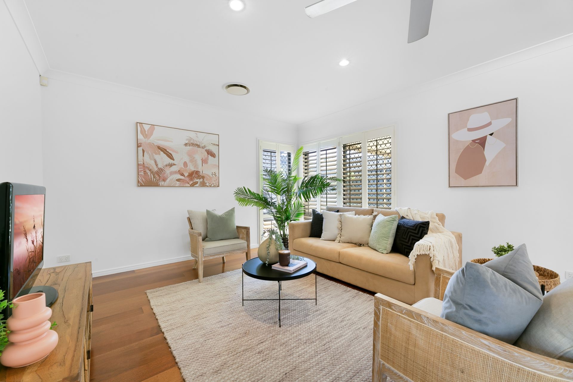 A living room with a couch , chair , coffee table and television.