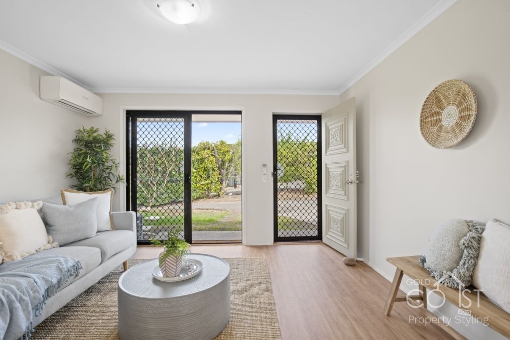 A living room with a couch , coffee table , and sliding glass doors.