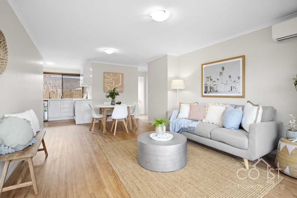A living room with a couch , table and chairs.