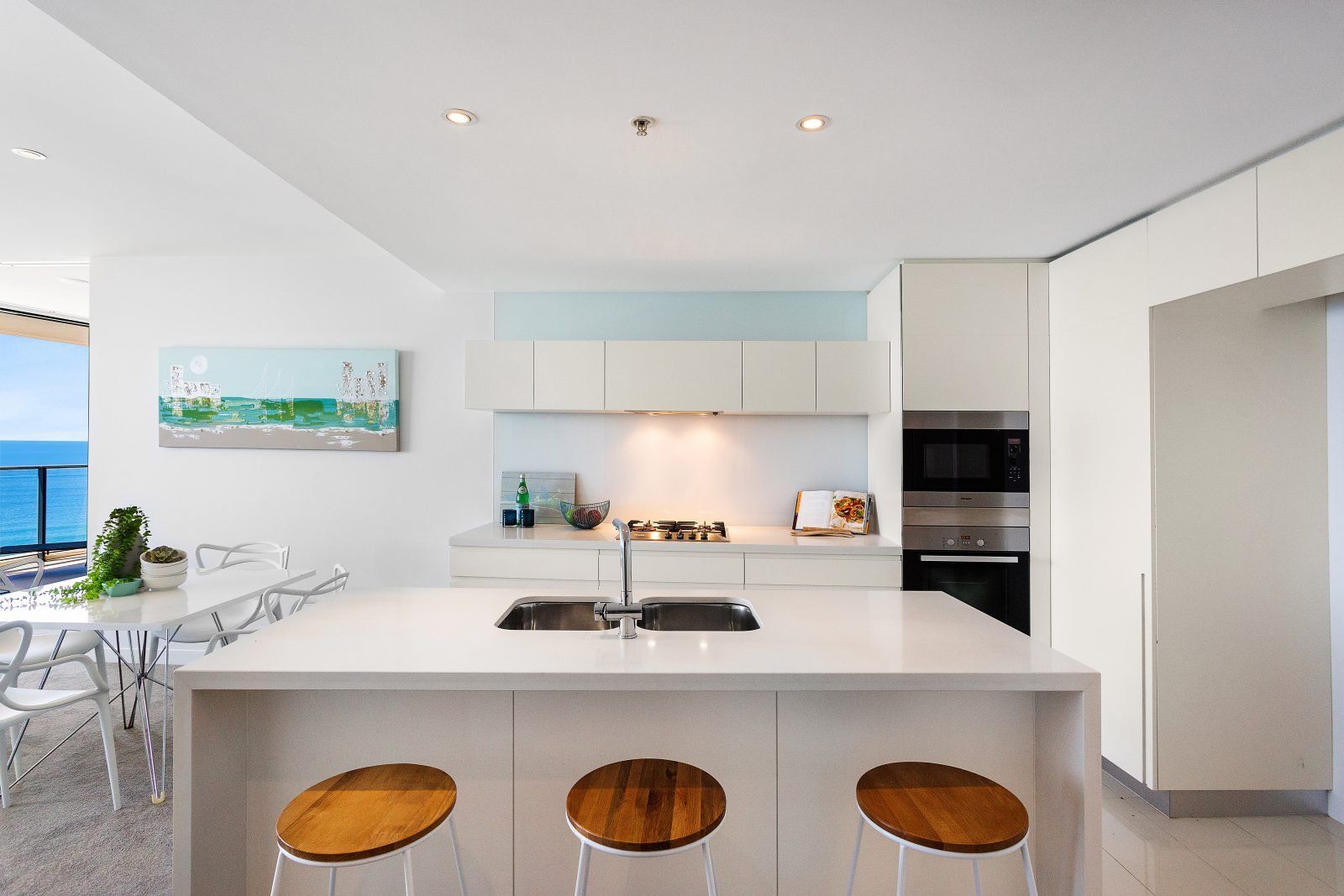 A kitchen with a large island and three stools