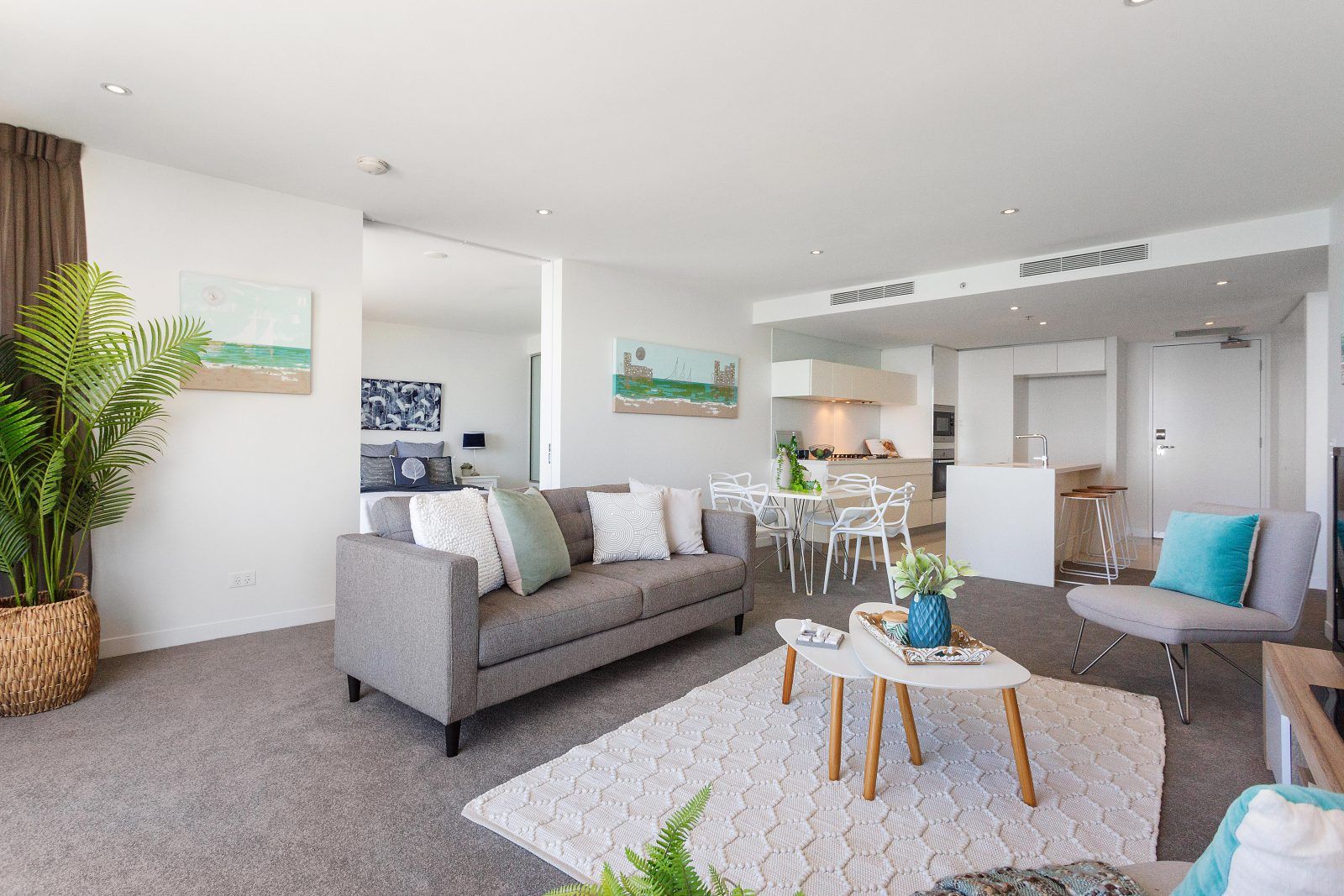 A living room with a couch , chairs , tables and a rug.