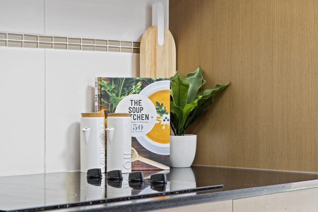 A kitchen counter with a potted plant and a book on it.