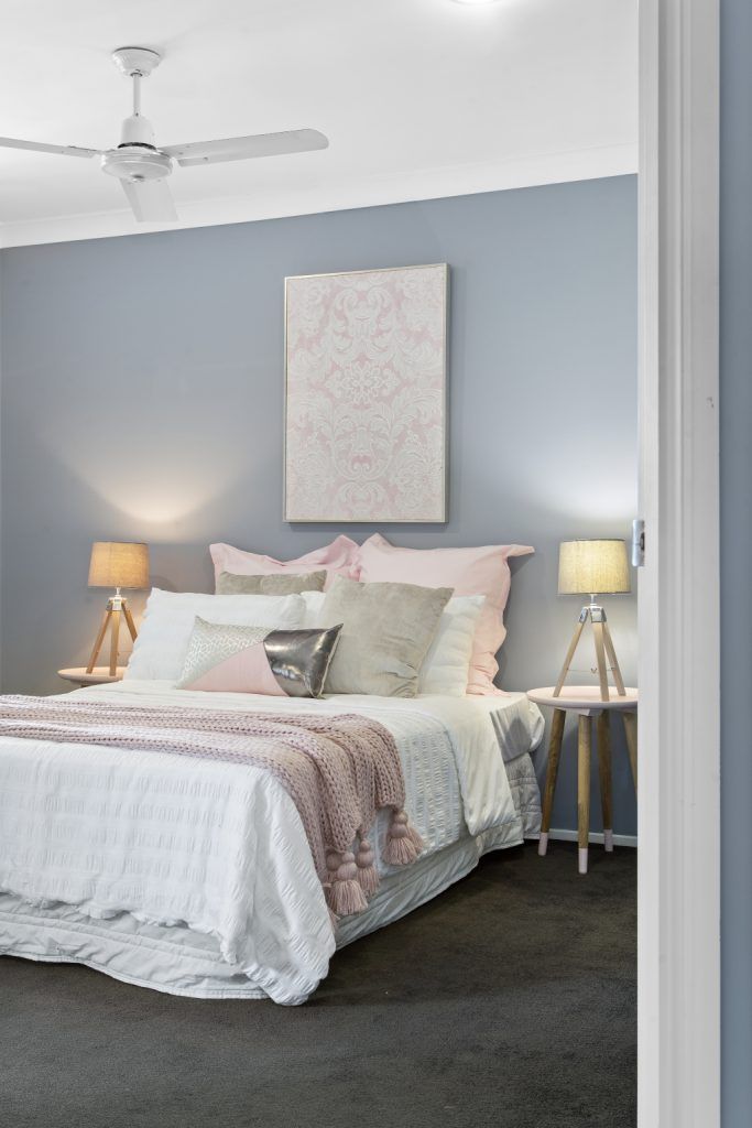 A bedroom with a bed and a ceiling fan.