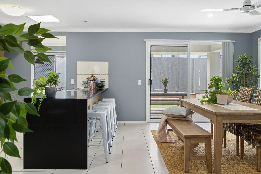 A living room with a table and benches and a sliding glass door.