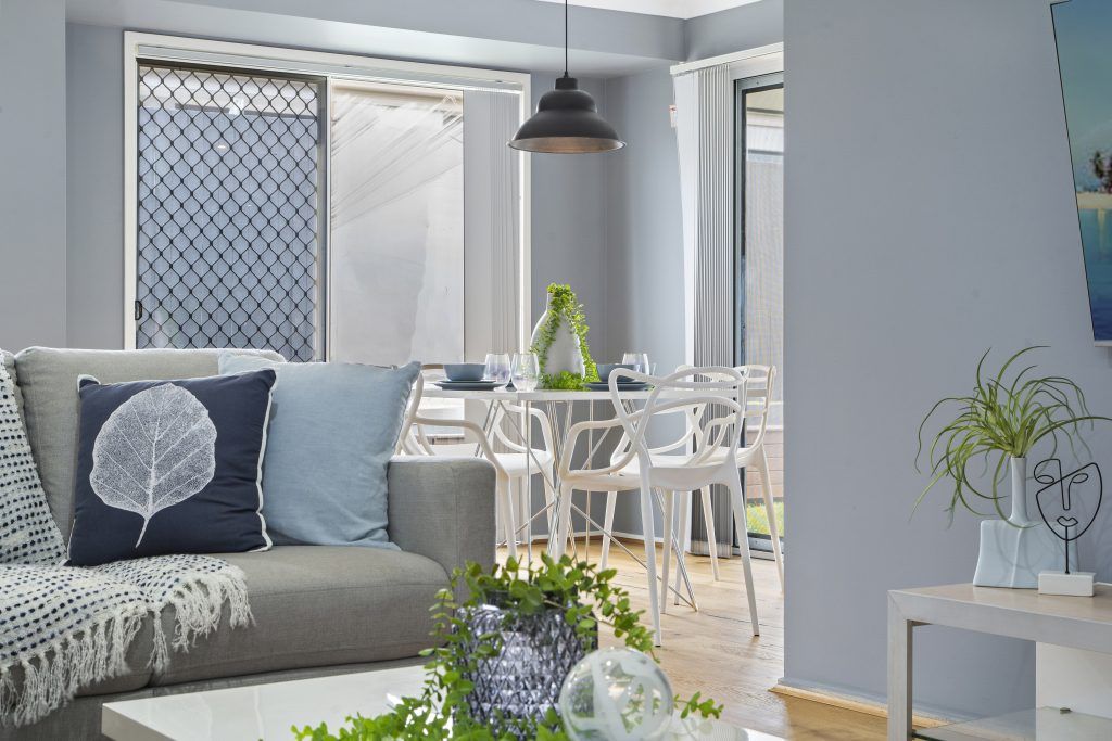 A living room with a couch , table and chairs.