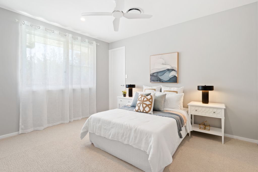 Bright minimalist bedroom with white bed, sheer curtains, and soft neutral decor