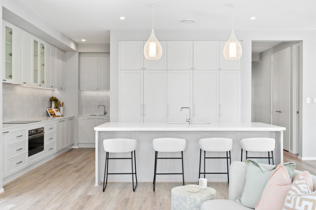 Bright white modern kitchen with island, pendant lights, and built-in cabinets