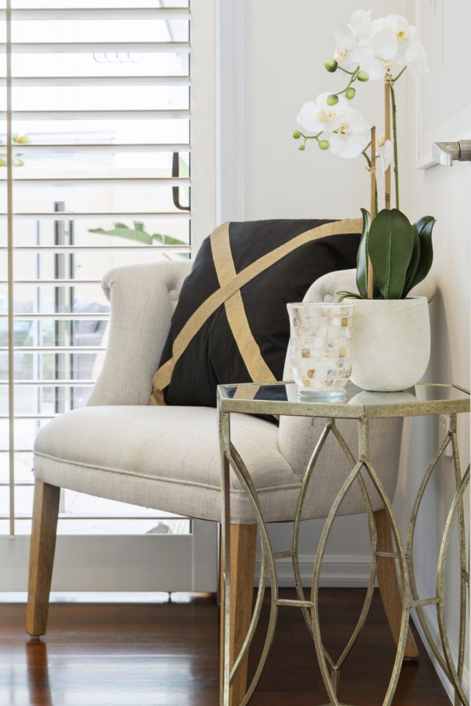 A chair is sitting next to a side table in a living room.