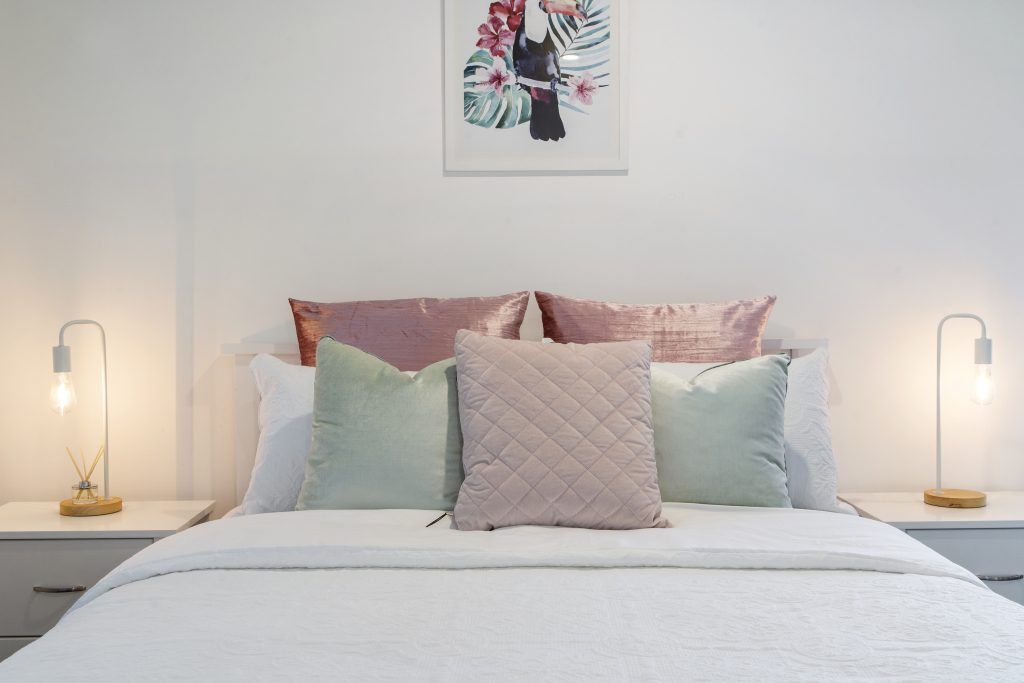 There is a picture on the wall above the bed.