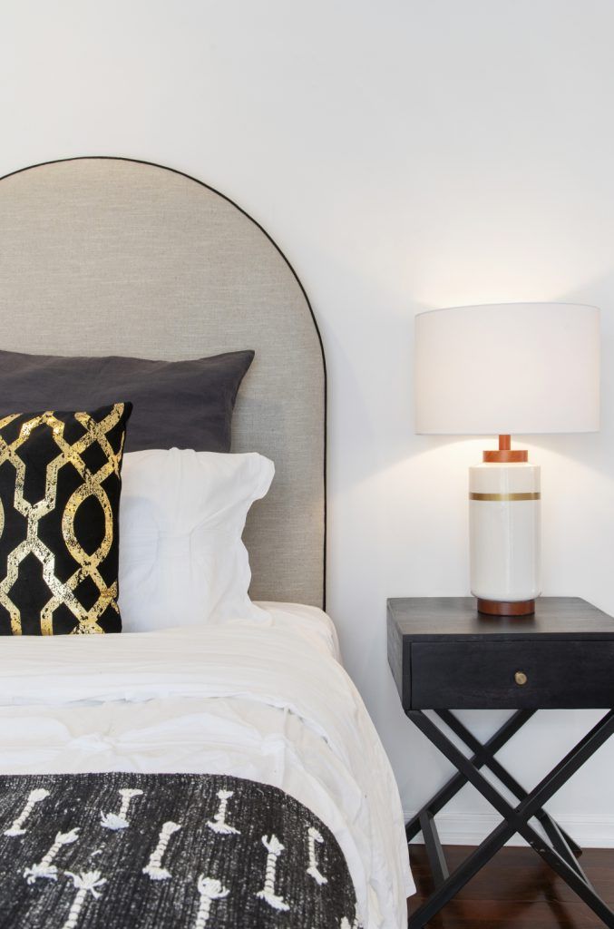 A bedroom with a bed , nightstand and lamp