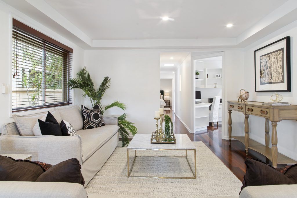 A living room with a white couch and a white coffee table