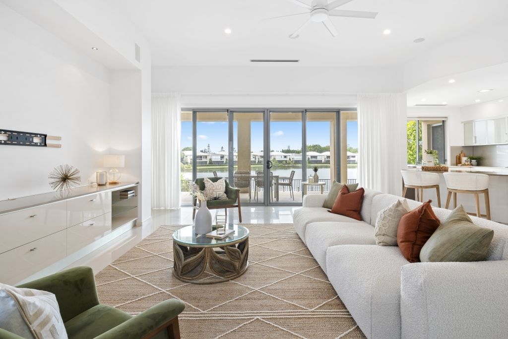 A living room with a couch , chair , coffee table and sliding glass doors.